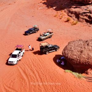 瓦迪拉姆Wadi Rum Silk Road Camp的沙漠沙地停泊的三辆车