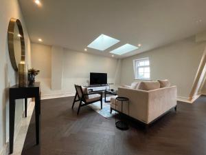 齐格威尔luxurious, 2 bed, 2 bath penthouse apartment in highly desirable Chigwell CHCL F8的带沙发和书桌的客厅