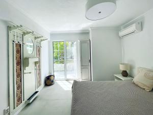 波托什Beach Villa Isidora的白色的卧室设有床和窗户