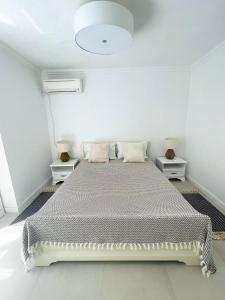 波托什Beach Villa Isidora的一间白色卧室,配有床和2个床头柜