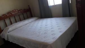 圣格雷戈里奥德波兰科Afecto的卧室内的一张床铺,配有白色床垫