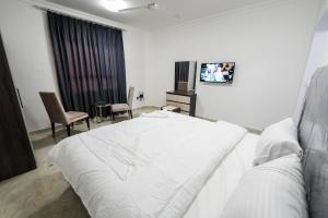 塞拉莱نسائم صلاله NassayemSalalah的卧室配有一张白色大床和电视。