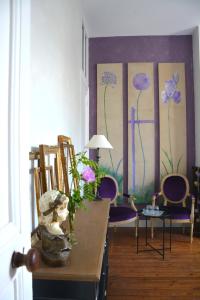 利布尔讷la maison的一间设有椅子和一张墙上鲜花桌子的房间