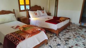 塔利温Auberge Restaurant Targa Taliouine的一间卧室配有两张带白色床单的床