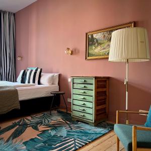 柏林布里丽安公寓酒店的一间卧室配有床、梳妆台和台灯。