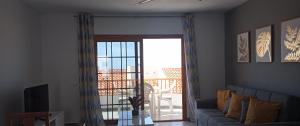 阿德耶HC home abroad Costa Adeje的带沙发和滑动玻璃门的客厅
