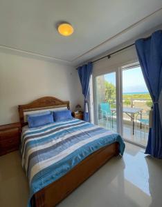 萨伊迪耶appartement vue sur mer saidia的一间卧室配有一张床,阳台配有桌子