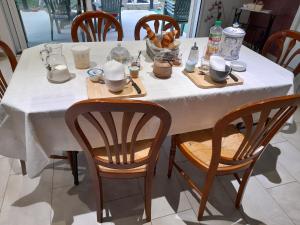 Celles-sur-BelleCHEZ VIVIANE的一张桌子、白色的桌布和木椅