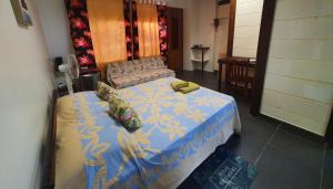 哈皮蒂Residence Vainau Moorea的一间卧室配有一张蓝色和黄色毯子的床