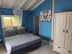 圣弗朗索瓦Chez Rustine et Pompette的蓝色客房中一间带床的卧室