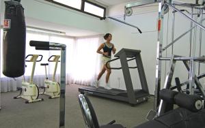 珊瑚湾卡洛利亚海滩公寓式酒店的站在健身房跑步机上的女人