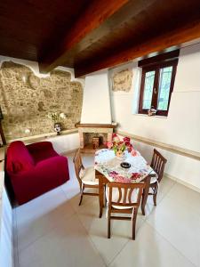 帕埃斯图姆IL GIARDINO DI ATHENA的客厅配有桌子和红色沙发