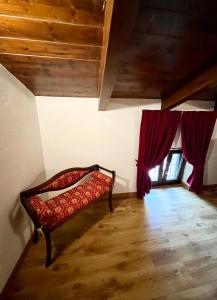 帕埃斯图姆IL GIARDINO DI ATHENA的一间设有长凳的房间,房间配有红色窗帘