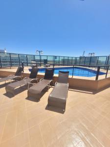 巴西利亚Lets Idea Brasília Hotel By Rei dos Flats的一组椅子坐在游泳池旁
