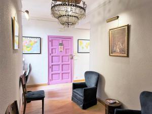 马德里圣马丁旅馆的一个带椅子和吊灯的房间的粉红色门