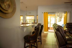 圣露西港Charming vacation home in Port St Lucie.的一间带酒吧和一些椅子的客厅