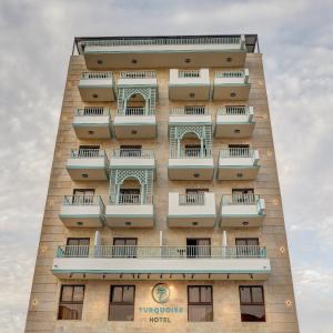亚喀巴Turquoise Hotel的一座高大的建筑,旁边设有阳台