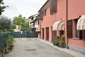 CasalgrandeCasa Emanuela, Il nostro Nido d'amore的一条空洞的小巷,上面有粉红色的建筑和雨伞