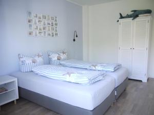 沙博伊茨Haffliebe 1的白色卧室配有两张床和条纹枕头
