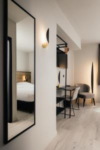 莱斯河畔的汉恩Hotel Au lit des ours的卧室内的镜子,配有一张床铺和一张桌子