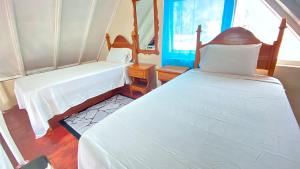 尼格瑞尔Oceanfront Condo w/ FREE Parking + High Speed Wifi的一间卧室设有两张床和窗户。