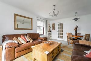 拉格斯Penthouse Seafront Largs的客厅配有棕色沙发和桌子