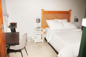 杰米斯顿Adorable 1.5 -Bedroom flatlet in Germiston的一间卧室配有一张床、一张桌子和一张四柱床。
