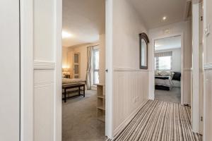 拉格斯Penthouse Seafront Largs的走廊上设有通往卧室的门