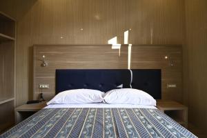 米兰Hotel Midway的一间卧室配有一张大床和蓝色床头板