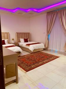 Al Fayşalīyahشقق الروشن الجوفي的一间卧室设有两张床和一个紫色的天花板