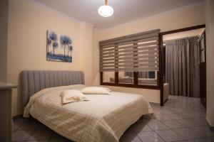 萨摩斯Ariadni Luxury Apartment的一间卧室设有一张床和一个窗口