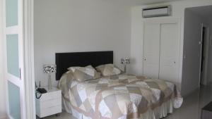 埃斯特角城Green Park Hermosos Apartamentos Vista al Lago的一间卧室配有一张床和一个带两盏灯的床头柜。