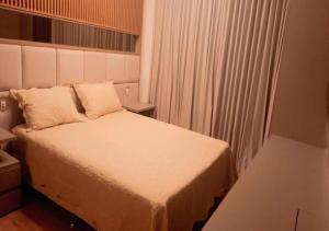 里约热内卢Apartamento luxuoso com infra completa próximo a Praia da Barra da Tijuca的卧室配有白色的床和窗户。