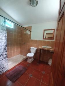 Santa CruzEl Encanto Garden Hotel的浴室配有卫生间、淋浴和盥洗盆。