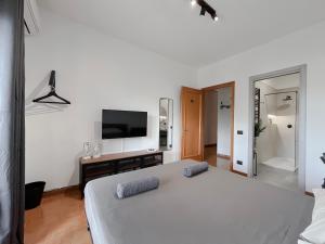 罗马Appartamento di design的卧室配有一张白色大床和一台平面电视。