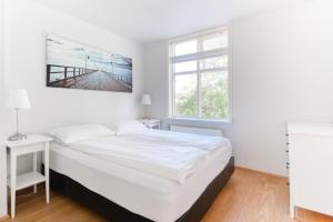 雷克雅未克塞姆公寓式酒店的白色的卧室设有一张大床和一个窗户