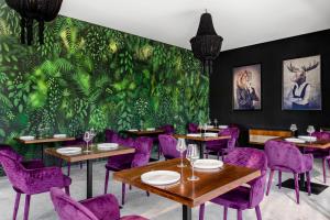 ChemuyilJungle Lodge Boutique Hotel - Adults Only的餐厅设有紫色桌椅和绿色的墙壁