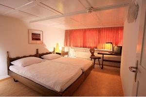 斯派克沙名博欧酒店的一间卧室配有一张床、一张书桌和一个窗户。