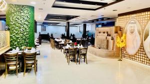 沙迦Daraysh Hotel的一间带桌椅和绿色墙壁的餐厅