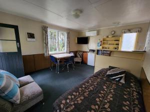 马纳普里Possum Lodge的一间卧室配有一张床铺和一张桌子,还设有一间厨房