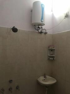 德拉敦9Backpackers Dehradun的浴室配有水槽和墙上的灯。