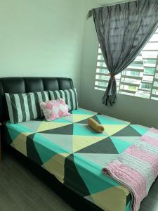 山打根Teratak kasih homestay的一间卧室配有一张色彩缤纷的床和窗户