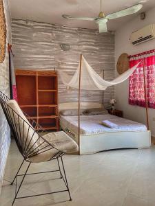 科托努La Guesthouse Étoile的卧室配有一张床、吊床和椅子