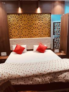 BalasoreHotel Nishi的一间卧室配有一张带红色枕头的大床