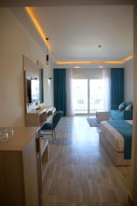 马萨阿拉姆Fantazia Resort Marsa Alam的酒店客房配有一张床、一张书桌和一张沙发。