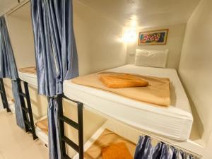 乔木提恩海滩Jomtien Beach Hostel的一间小房间,内设两张双层床