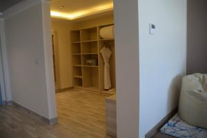 马萨阿拉姆Fantazia Resort Marsa Alam的客房设有带白色墙壁和木地板的衣柜。