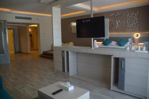 马萨阿拉姆Fantazia Resort Marsa Alam的酒店客房设有带平面电视的前台。
