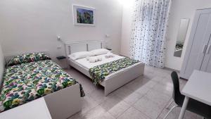 卡塔尼亚Marricrio House的一间卧室配有两张床、一张桌子和一张书桌