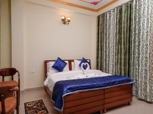 西姆拉Divine Hills Mashobra的一间卧室配有一张带蓝色枕头的床